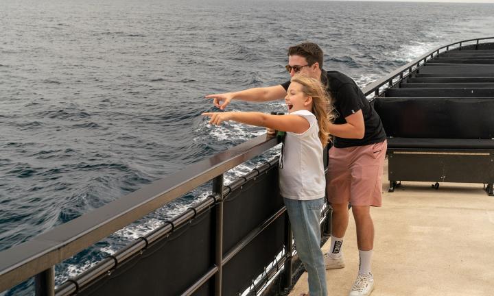 Young family pointing out whales