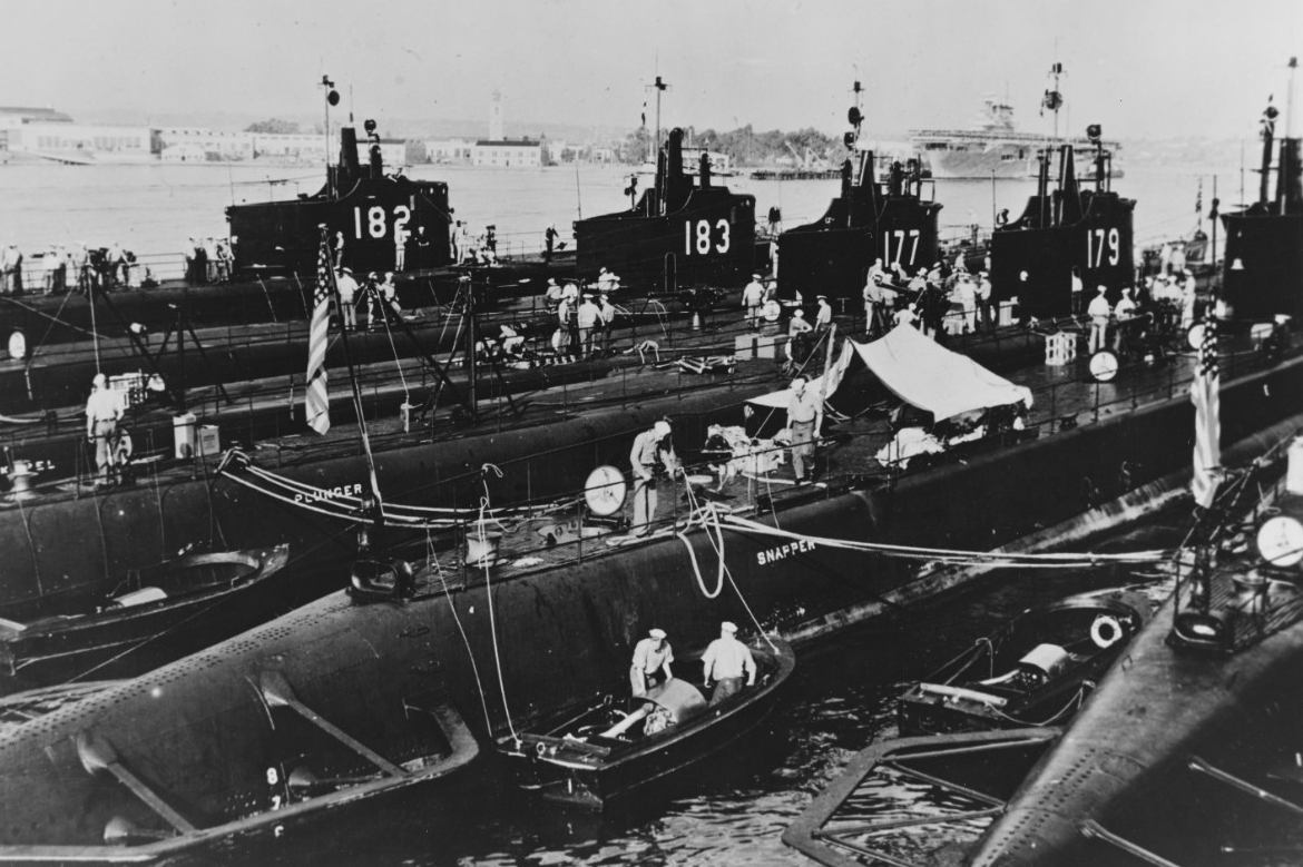 Six U.S. Navy submarines sit moored together in San Diego Harbor